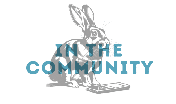 Illustration of a rabbit sitting next to a smartphone with the words "IN THE COMMUNITY" overlaid, highlighting Montgomery County TX at Two Step Farm.